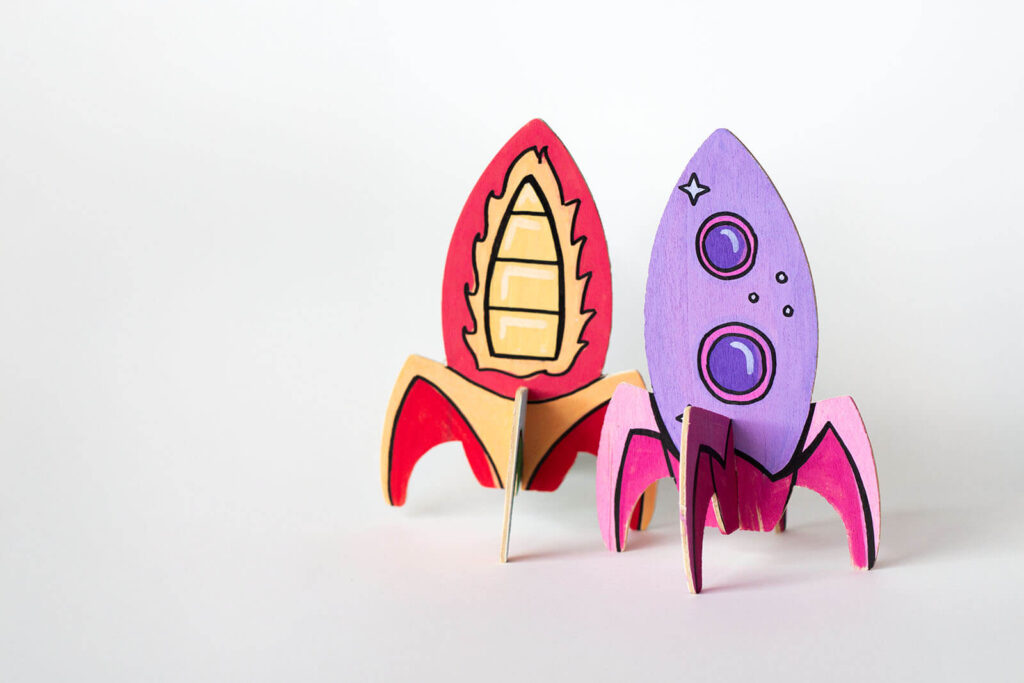 Bunte Holzraketen bemalen, die zusammengesteckt sind und das Endergebnis zeigen